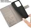 A hand is holding a black phone case, showing how it fits into a gray flip case with card slots and a floral design. Produktbild-Vorschau
