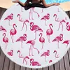 Rundes weißes Strandtuch mit rosa Flamingo-Muster und Fransensaum, Arme und Oberkörper einer Person oben am Pool sichtbar Anteprima dell’immagine prodotto