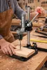 A person is using a drill press to drill a hole in a piece of wood. Náhľad obrázku produktu