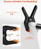 Close-up of black and orange clamps used to secure a white backdrop. Náhľad obrázku produktu