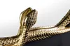 A close-up of a decorative gold snake sculpture. Produktbild-Vorschau