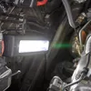 A work light illuminates the engine bay of a vehicle. Produktbild-Vorschau