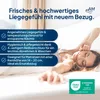 A woman stretching in bed with a mattress cover. Produktbild-Vorschau