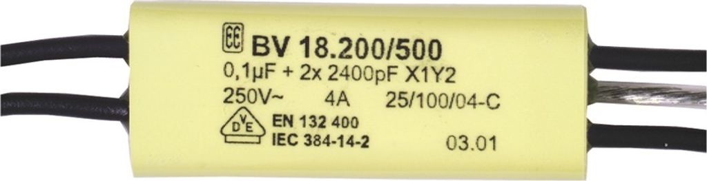 A close-up of a yellow capacitor with black and gray wires.