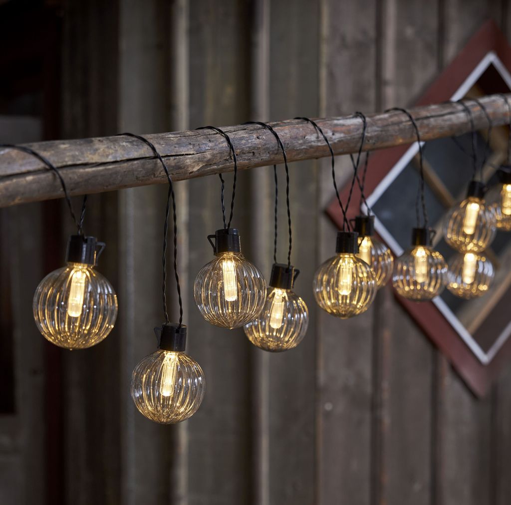 A string of decorative lights hanging from a wooden beam.
