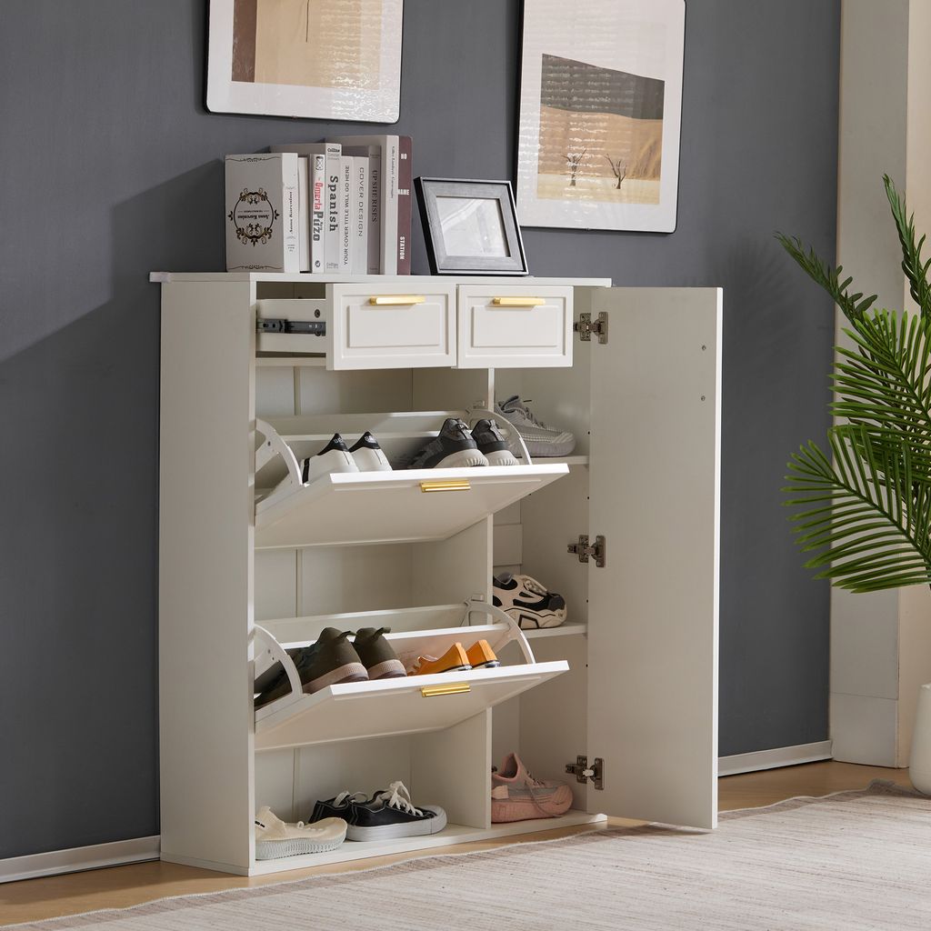 A white shoe cabinet with two drawers and multiple shelves is shown in a room with a gray wall and a plant.