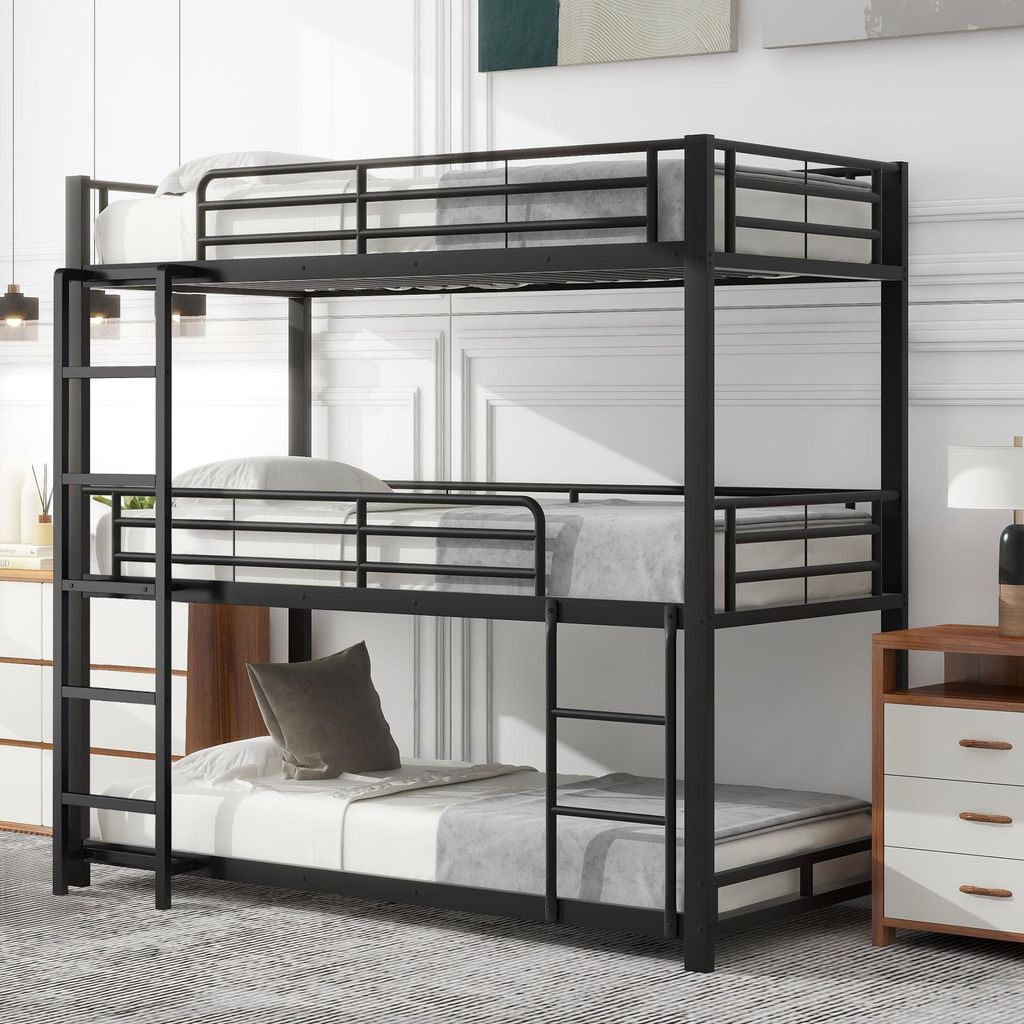 A triple bunk bed in a room with a dresser and a lamp.