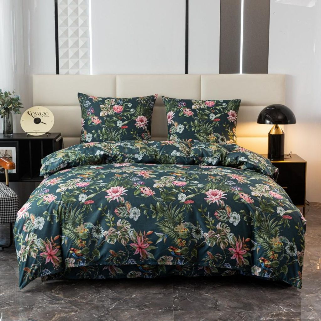 A neatly made bed with a floral patterned duvet and pillows, set against a headboard and bedside tables with a lamp and clock.