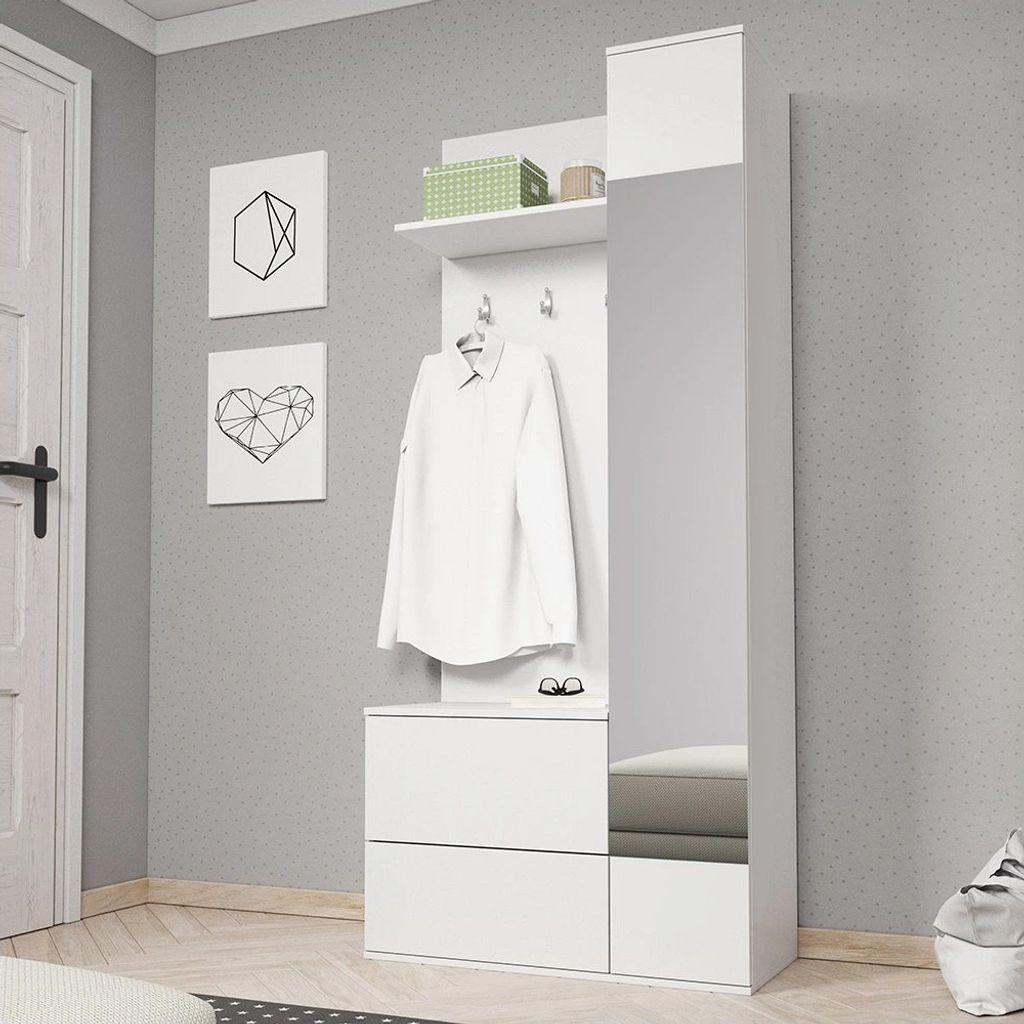 A white hallway furniture unit with a mirror, shelf, and drawers, with a white shirt hanging on a hook.