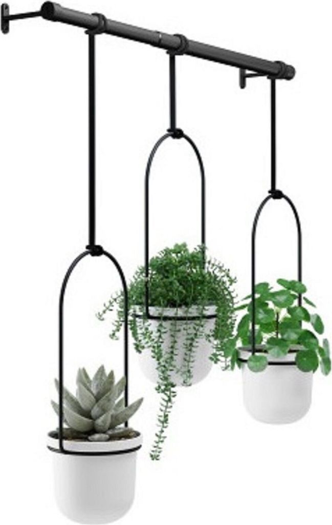 Three white planters with plants hanging from a black metal bar.