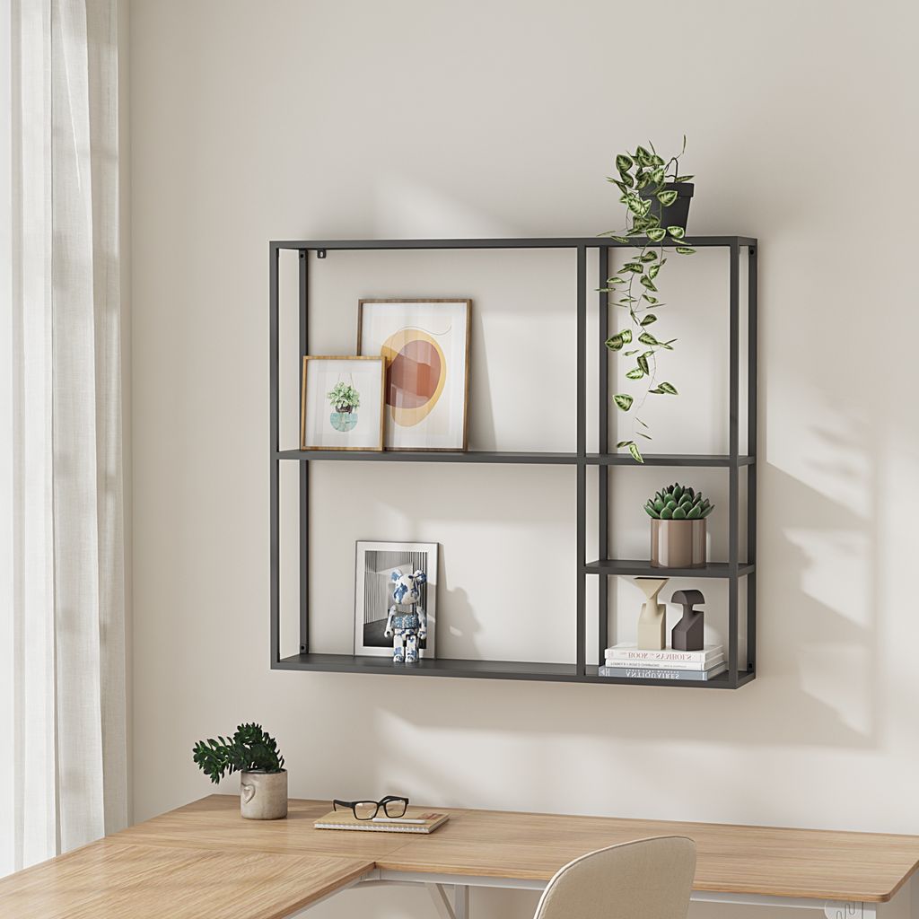 A modern wall shelf mounted above a wooden desk, decorated with plants and framed pictures.