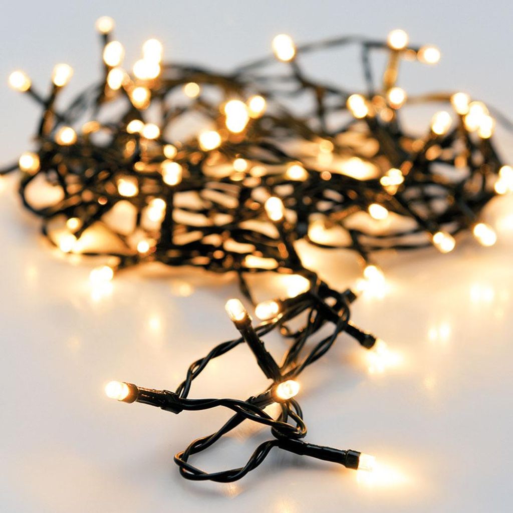 A close-up shot of a string of warm white LED lights coiled on a white surface.