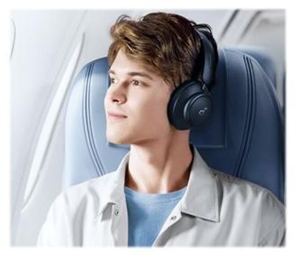 A young man wearing headphones on an airplane.