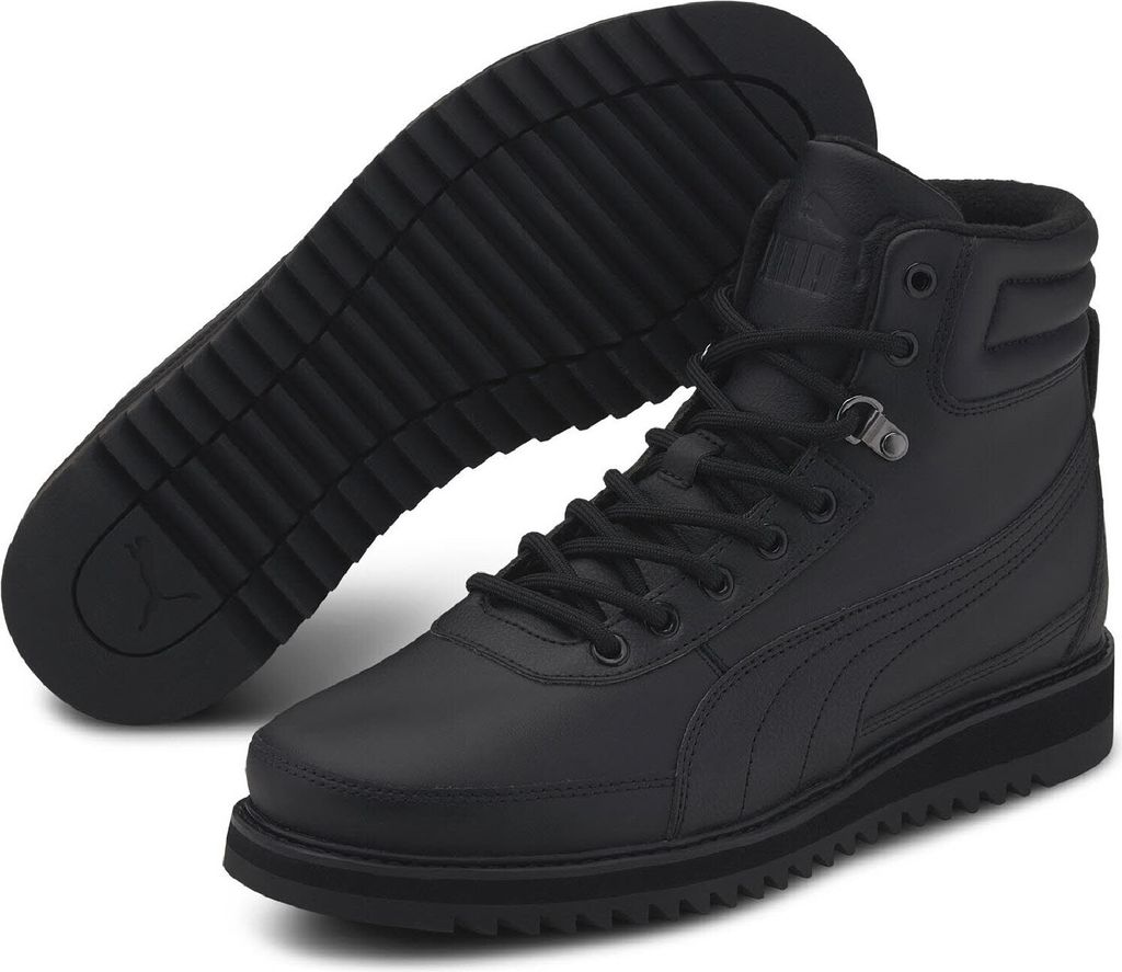 A pair of black Puma boots shown from a diagonal angle, with one boot standing and the other lying on its side to show the sole.