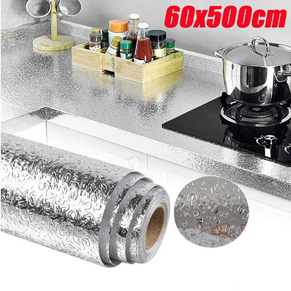 A kitchen counter with a roll of foil, a pot on a stove, and various spices.