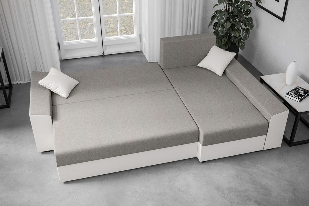 A sectional sofa is shown in a room with large windows and curtains.
