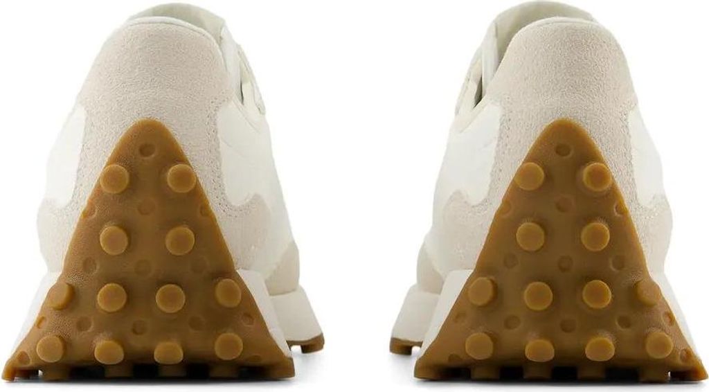 The back view of two beige New Balance sneakers with brown rubber soles.