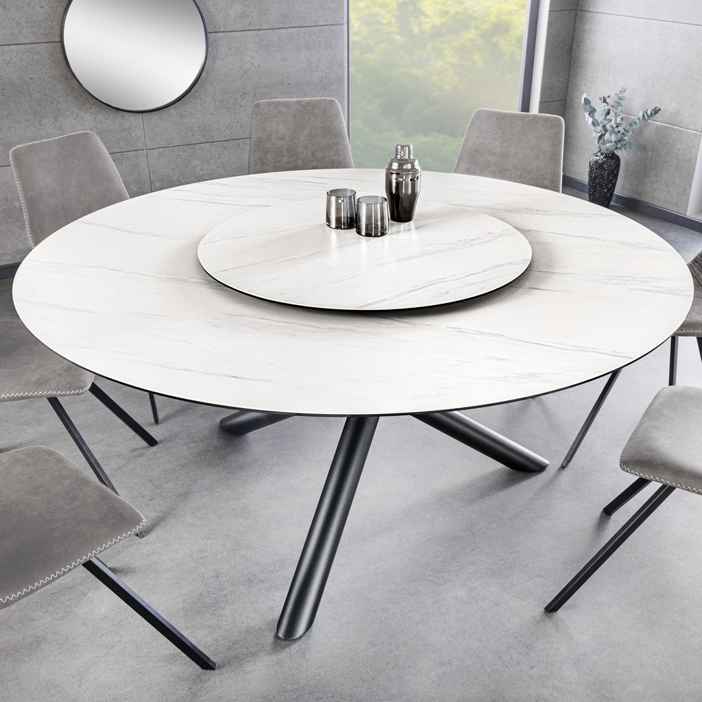A modern dining room setting with a round dining table and chairs.
