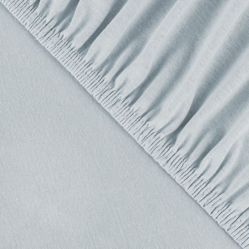 A close-up view of a light blue fitted sheet with elastic gathering along the edge.
