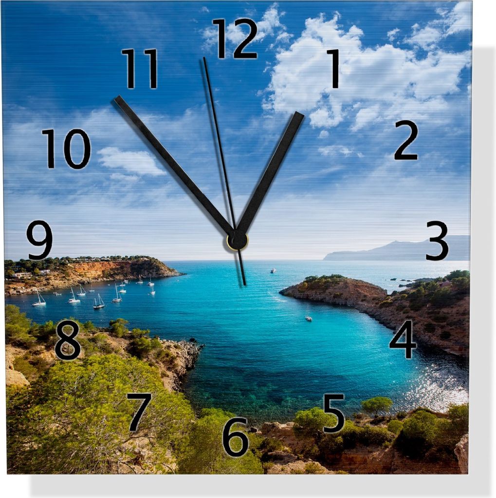 Wallario Design Wanduhr Ibiza - Blick von einer Bucht aufs Meer aus Aluverbund, Größe 30 x 30 cm