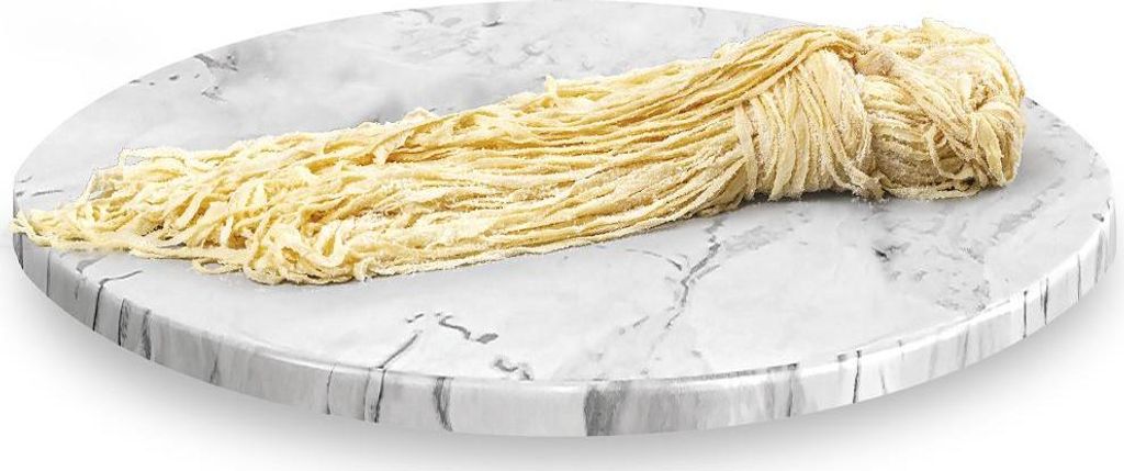 A bundle of yellow noodles is placed on a round marble-like surface.