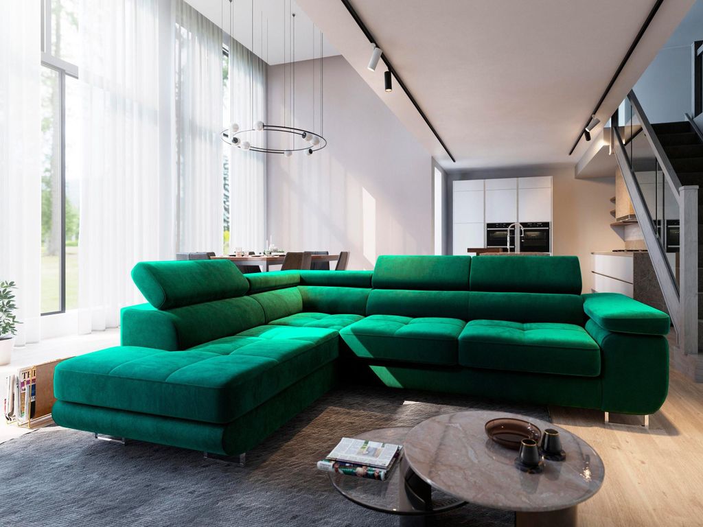 A modern living room with a large green sectional sofa, a coffee table, and a dining area in the background.