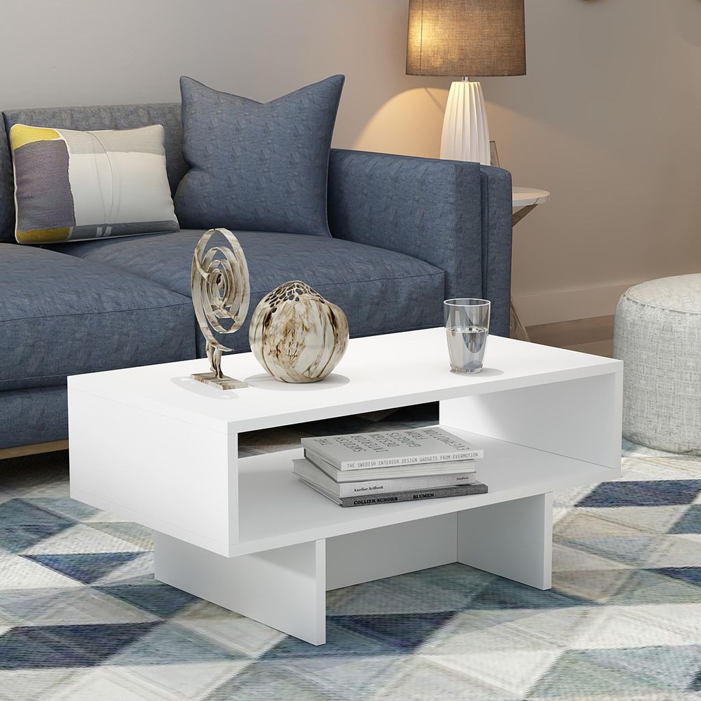 A modern living room scene with a blue sofa, a white coffee table, and decorative items.