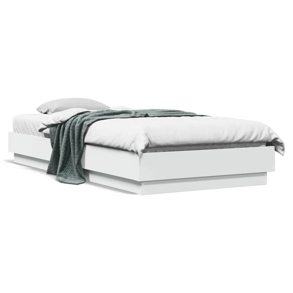A white platform bed frame with a mattress and green blanket against a white background.