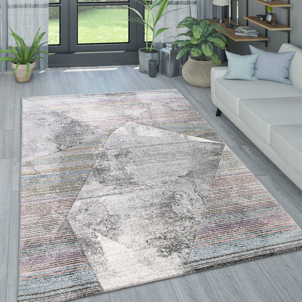 A living room scene with a rug, sofa, and plants.