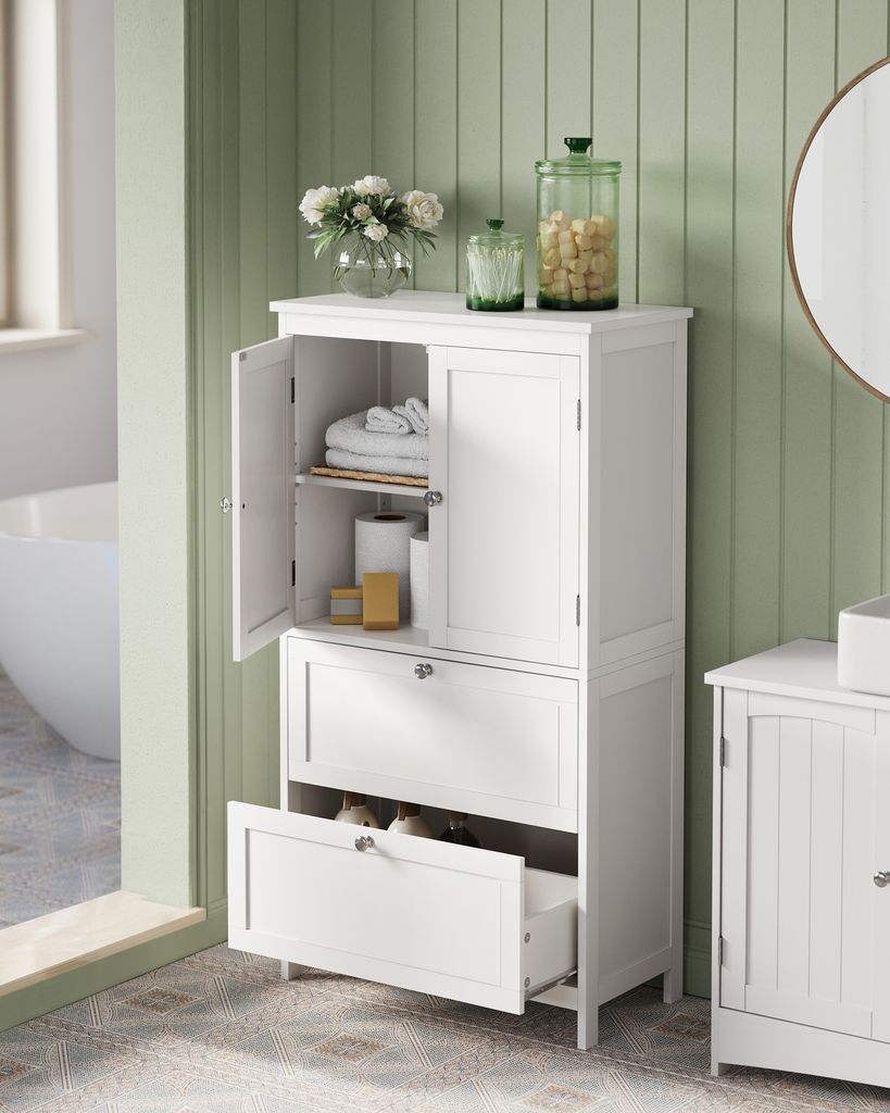 A white bathroom cabinet with open doors and one drawer pulled out, showing storage space. Decorative items like flowers and jars are on top of the cabinet.