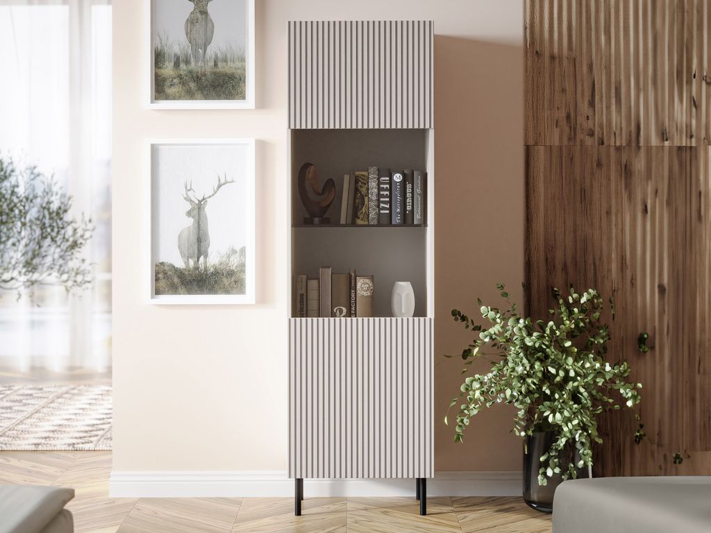 A tall, narrow display cabinet with a fluted front is shown in a well-lit room with decorative artwork and a plant.