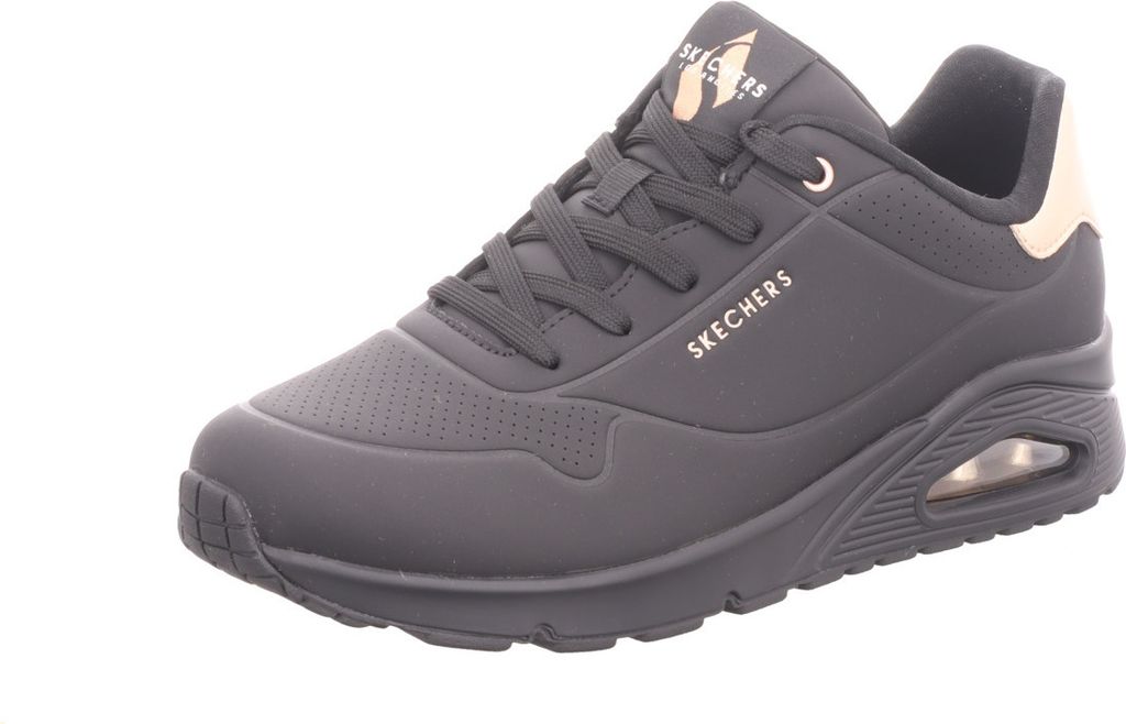 A black Skechers UNO sneaker with gold accents is shown from a side angle against a white background.