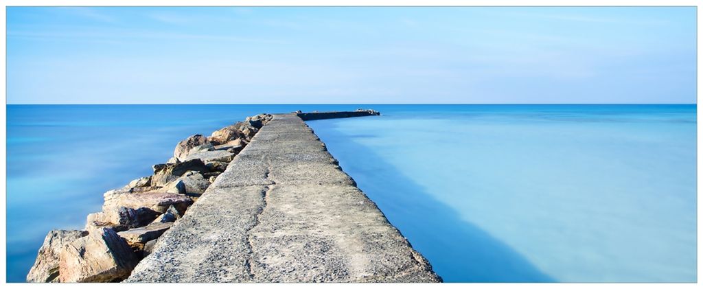 Wallario Wandbild aus Acryl, 200 x 80 cm, freischwebende Optik - Pier am blauen Ozean mit blauem Himmel
