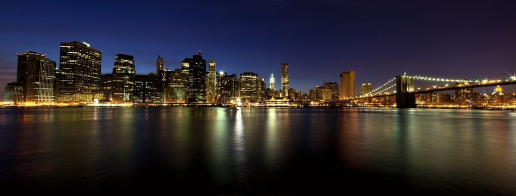 Wallario Premium Glasbild, freischwebende Optik, kräftige Farben, Größe 125 x 50 cm Motiv New York Skyline - Brooklyn Bridge und Manhattan am Abend