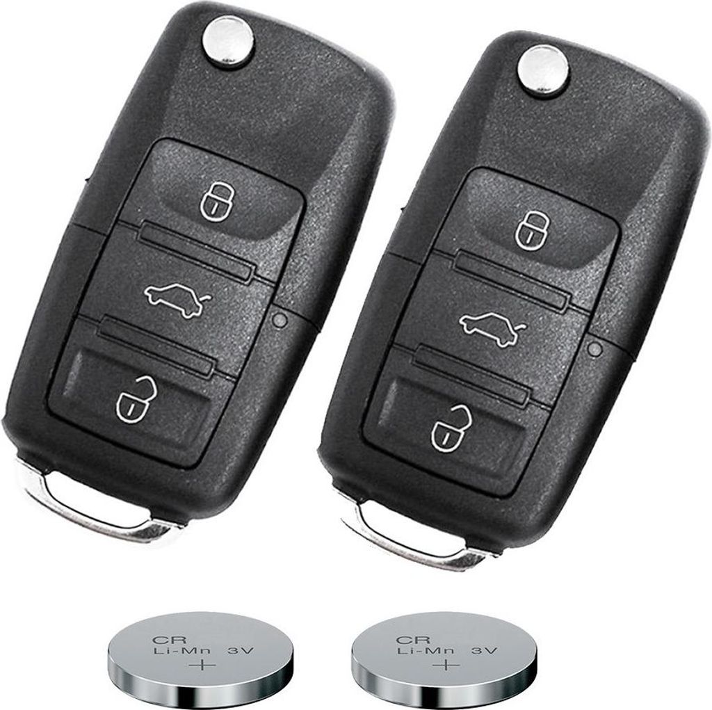 Two black car key fobs and two coin cell batteries are shown against a white background.