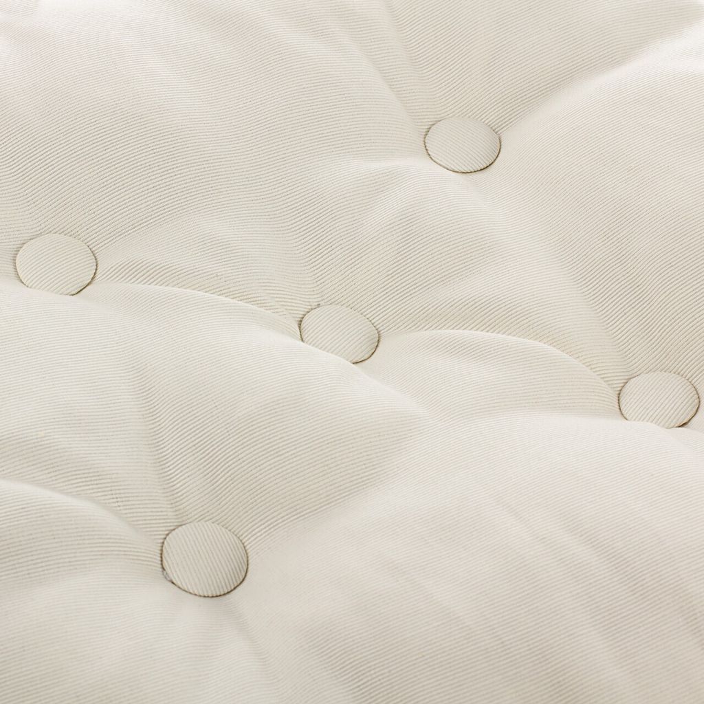 A close-up view of a tufted cushion with visible stitching and buttons.