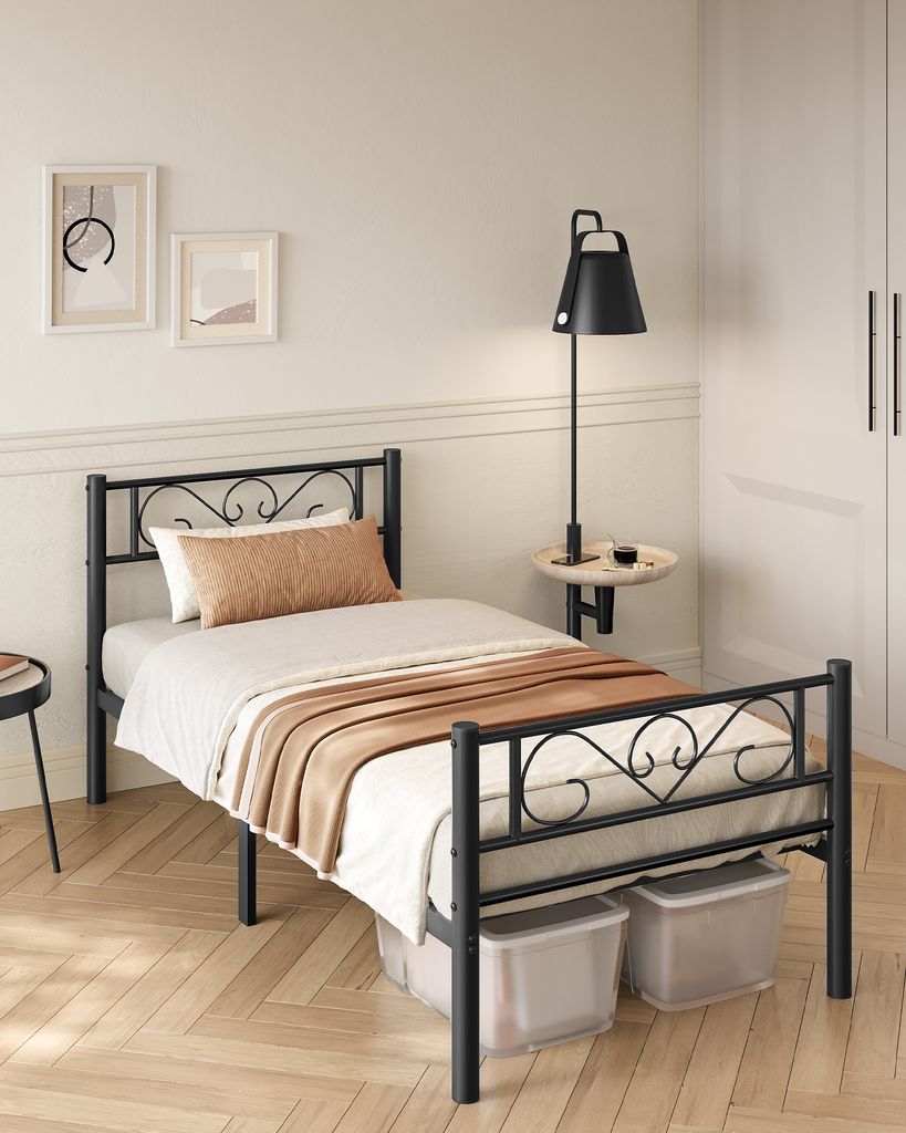 A bedroom setting with a single black metal bed frame.