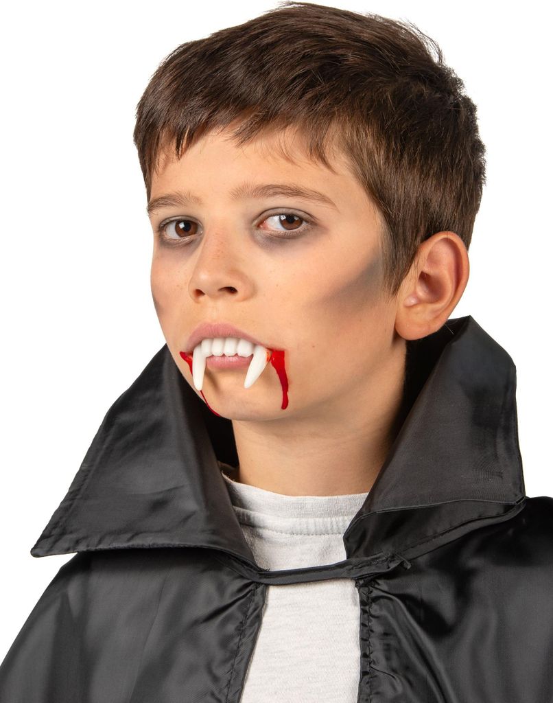 A young boy wearing a black cape and vampire fangs with fake blood.
