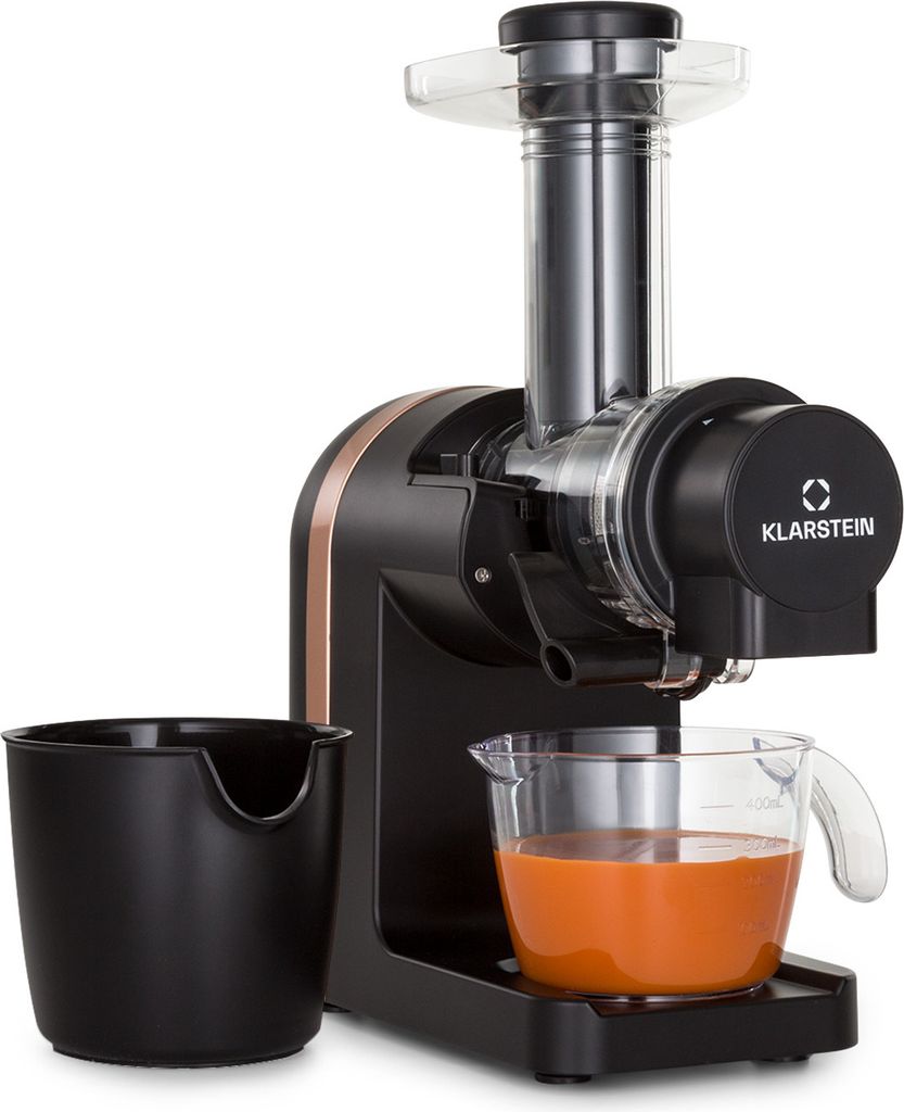 A black and copper juicer is shown against a white background, with a black pulp container and a glass pitcher filled with orange juice.