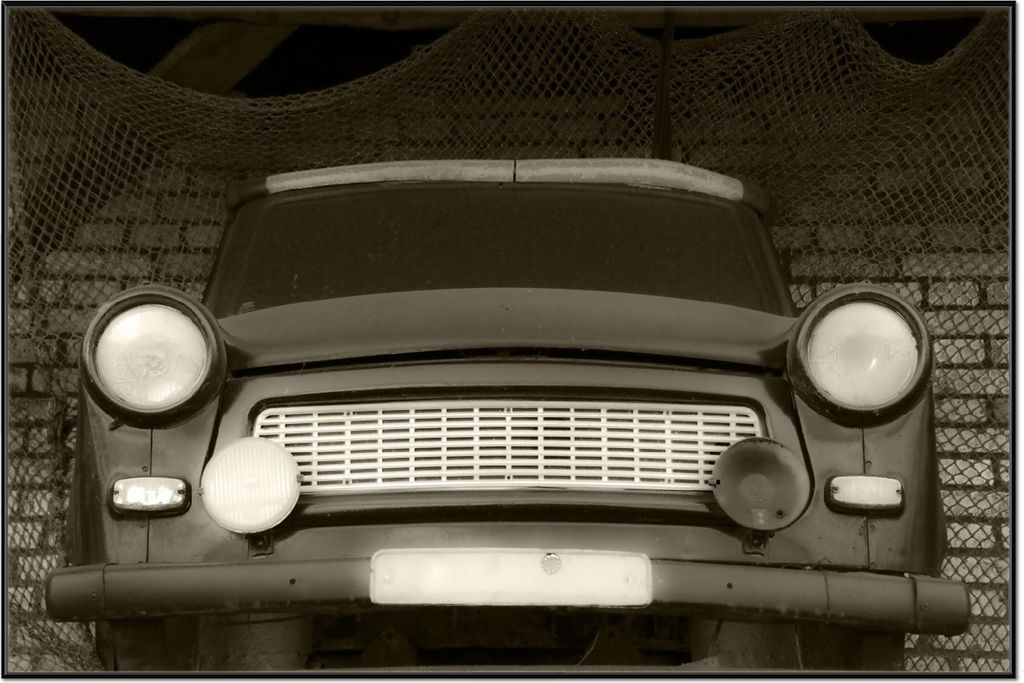 Wallario Wandbild Alter Trabbi in schwarz-weiß - Frontansicht Scheinwerfer, Größe: 61 x 91,50 cm, Poster mit schwarzem Aluminiumrahmen