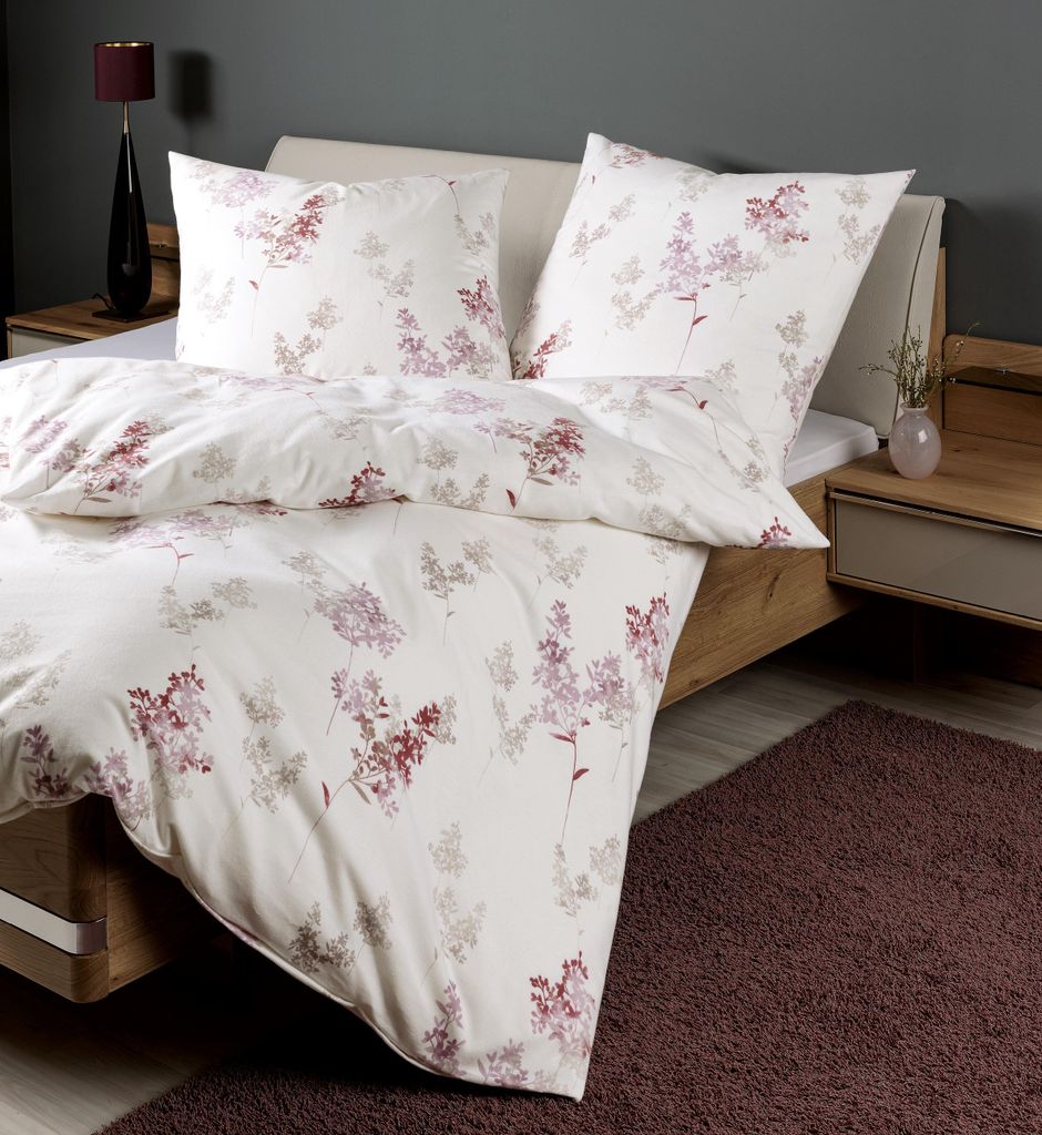 A neatly made bed with floral patterned bedding.