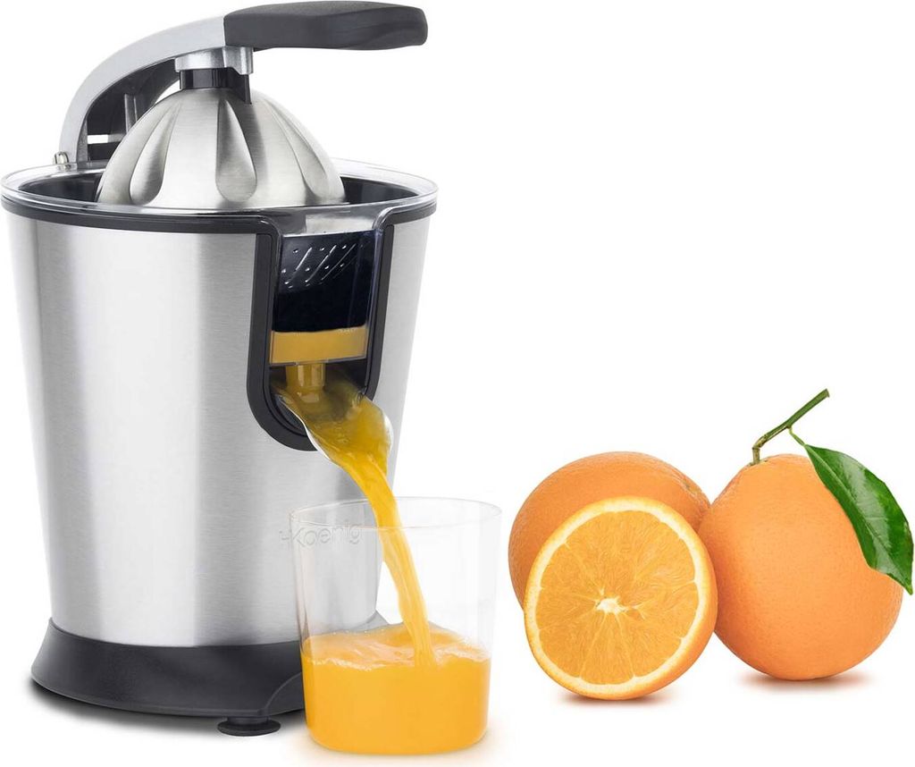 A stainless steel electric citrus juicer is shown in operation, with fresh orange juice pouring into a glass. Two whole oranges and one half-orange are placed next to the juicer.