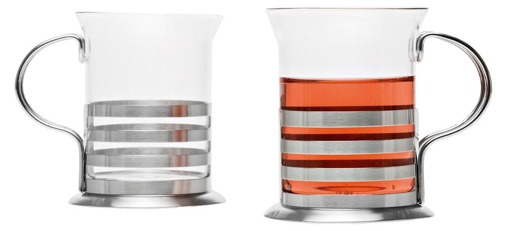 Two glass teacups with metal accents, one filled with a red beverage.