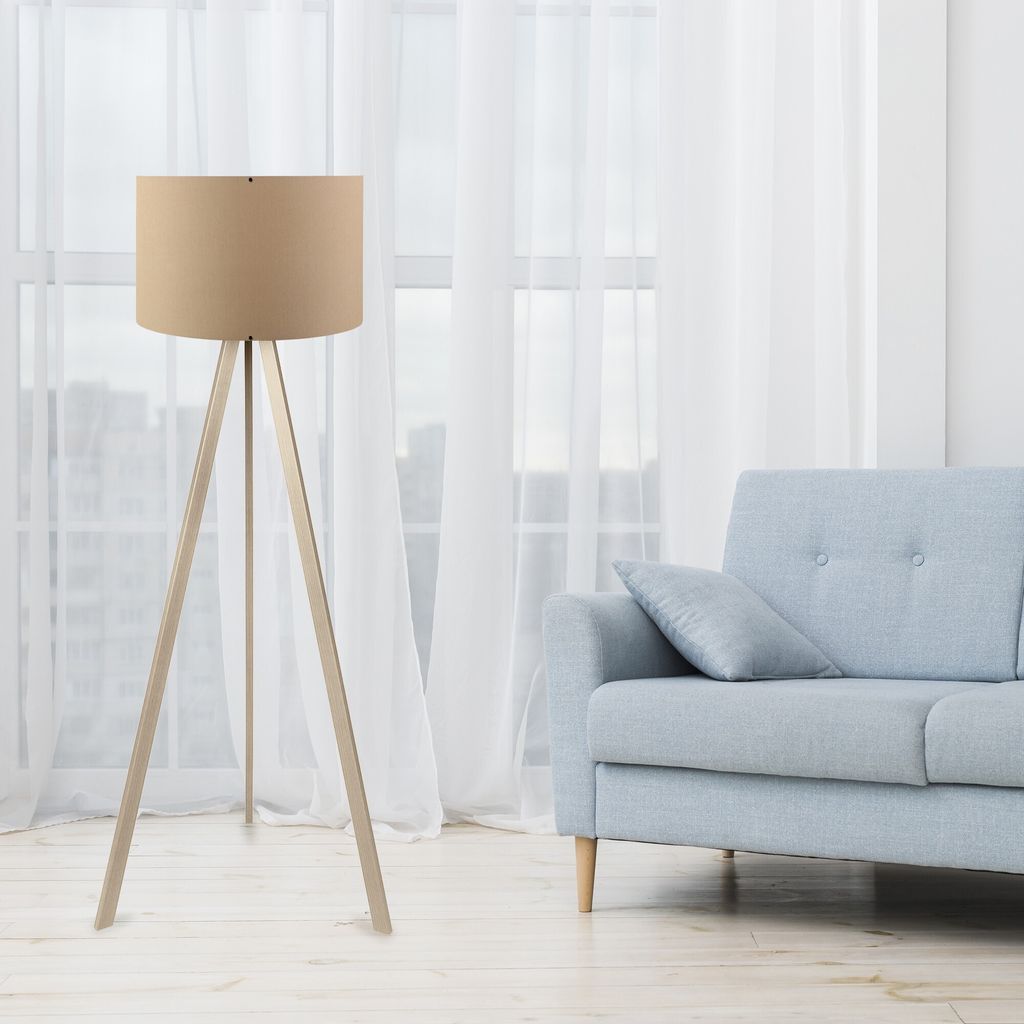 A floor lamp and a sofa are shown in a room with sheer curtains.