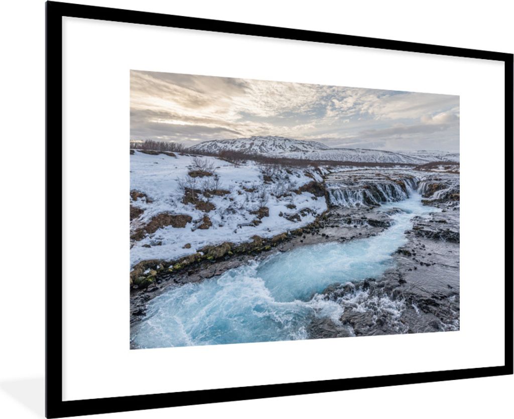MuchoWow Gerahmtes Poster Leuchtend blauer Wasserfall inmitten der Winterlandschaft am Geysir 90x60 cm - Poster mit Schwarzem Bilderrahmen Wandpo...