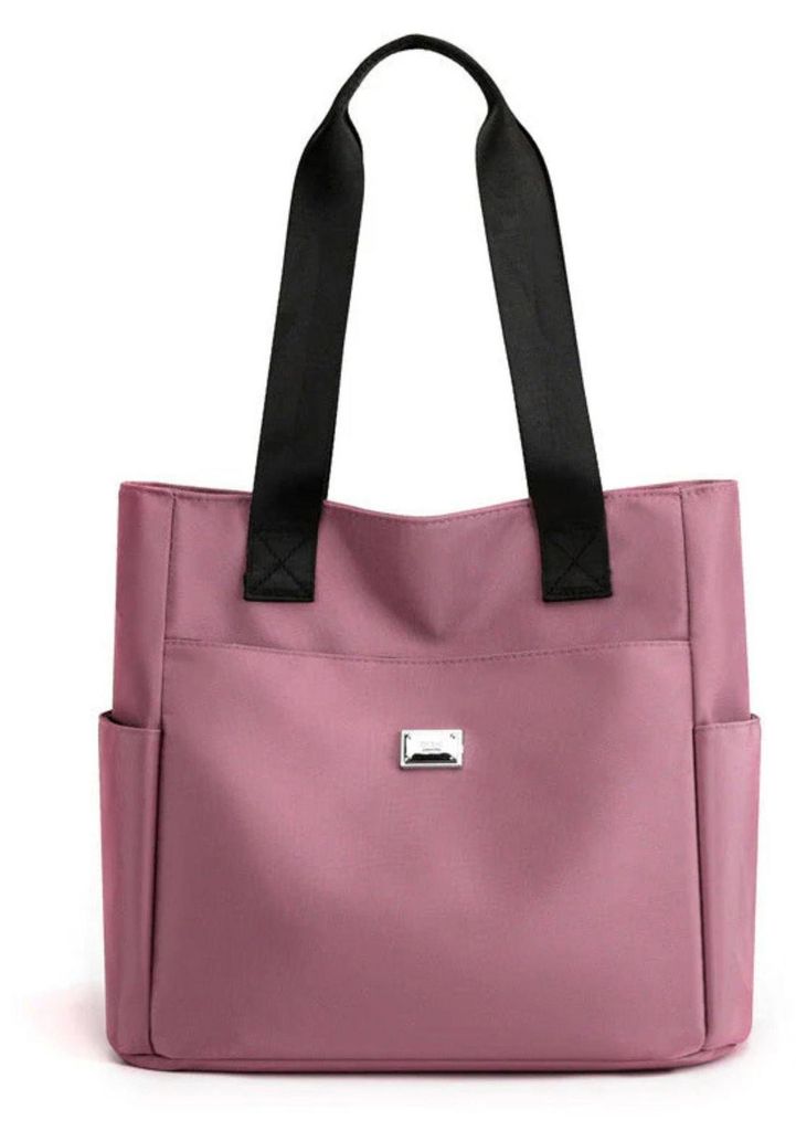 Rosa Stofftasche mit schwarzen Henkeln und zwei Seitentaschen, von vorne gezeigt