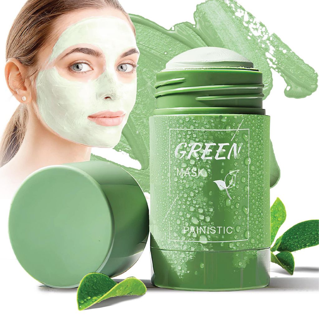 A woman is applying a green face mask, with the product packaging prominently displayed.