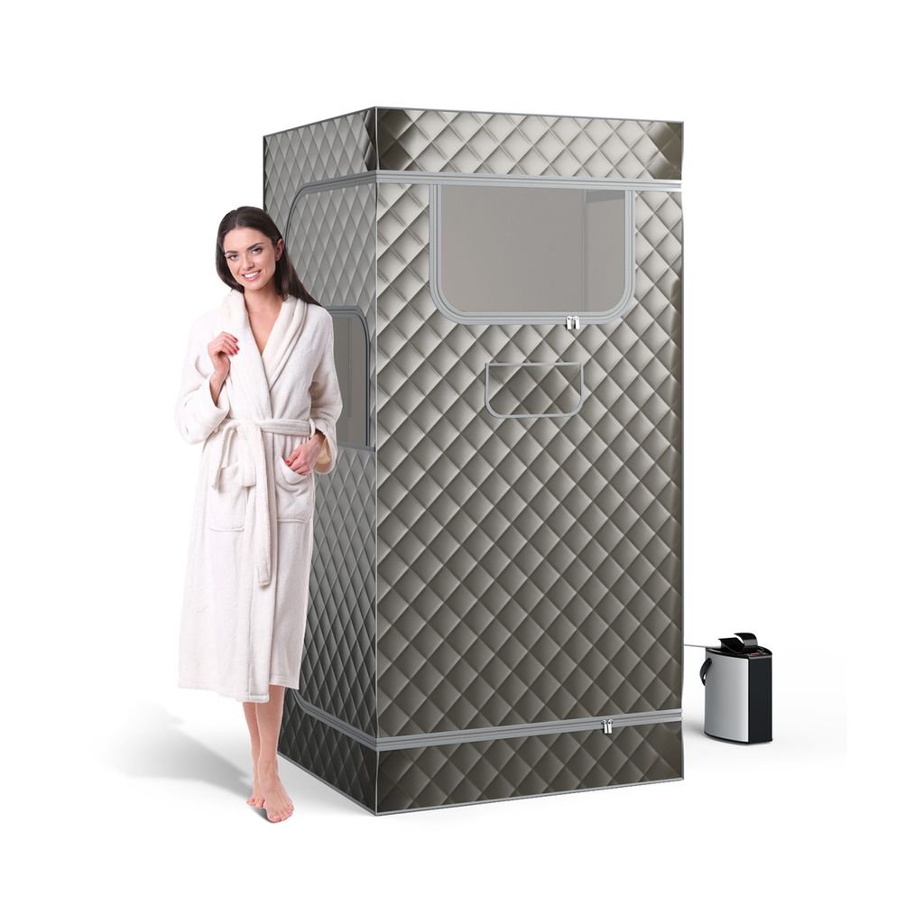 A woman in a bathrobe stands next to a portable steam sauna.