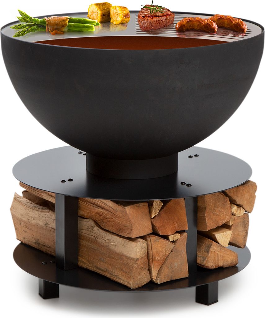 A black metal fire pit with a grill grate on top, holding food items, and a wood storage base.