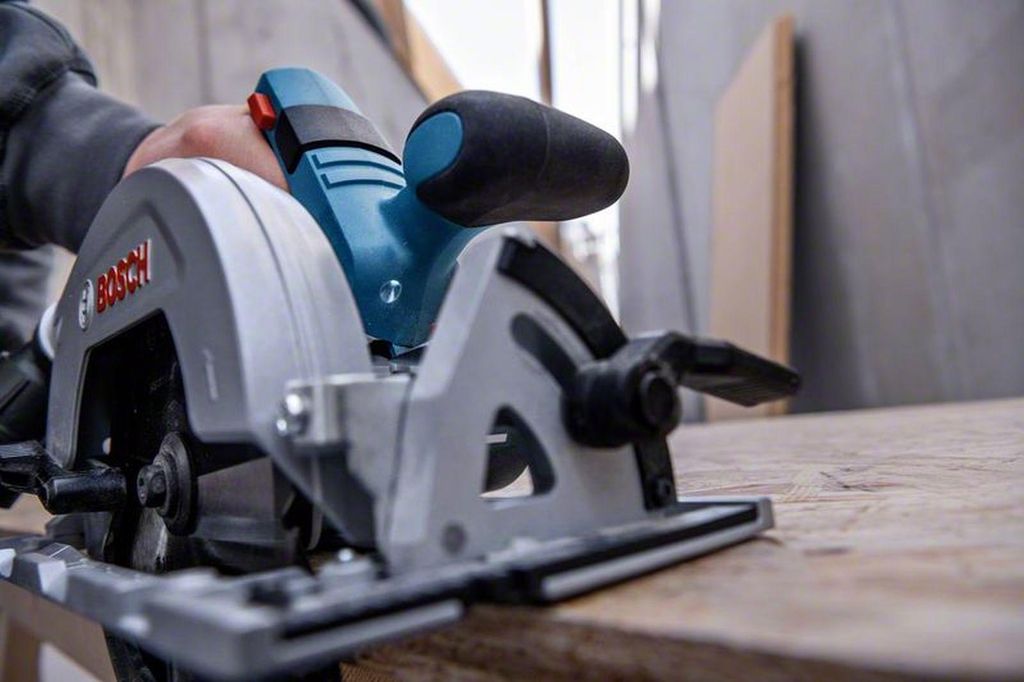 A person is using a Bosch circular saw to cut wood.